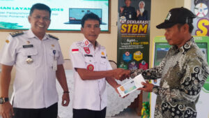 Ketua RT memegang HP bantuan program digitalisasi desa Margasari